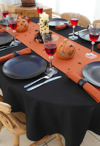 Black tablecloth with orange halloween table runner, pumpkin and spider decorations