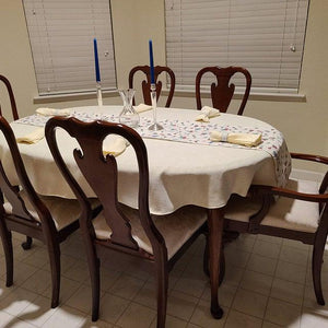 White oval tablecloth with a lot of texture, formal dining room