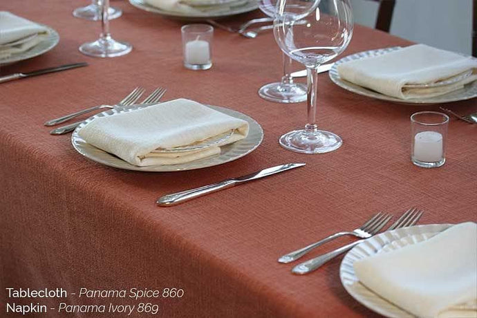 Spice colored Panama Table cloth with glasses, silverware, and ivory napkins on plates