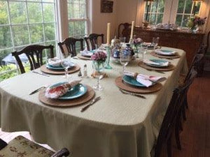 Panama table cloth on a large family table with placemats, plates, and candles