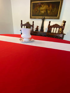 Fine linens on a an oval home dinner table with a white runner