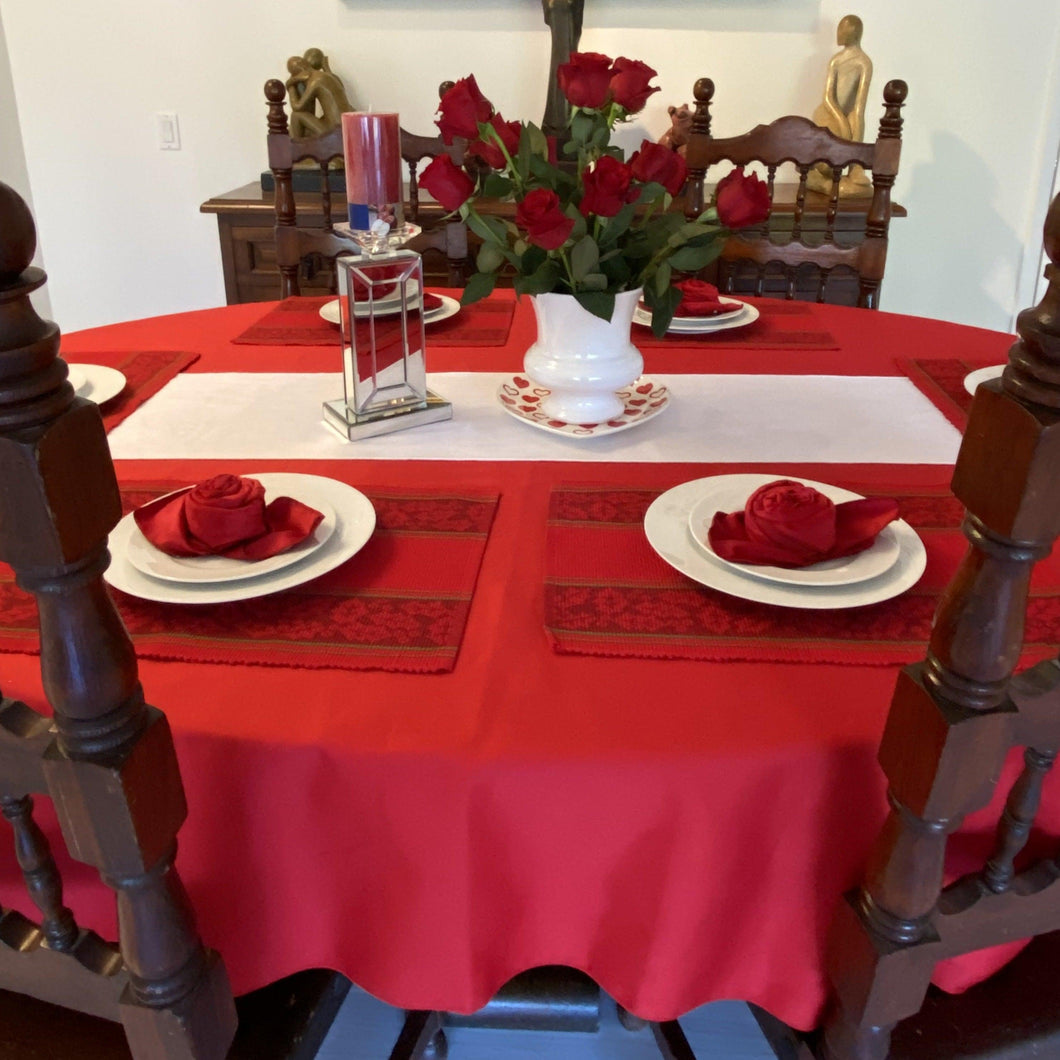 Fine linens on an oval table with Flowers and plates