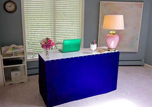 Poly premier skirt on a desk in a home office setting with laptop computer and desk lamp