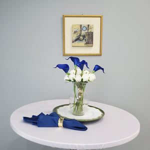 White round fitted tablecloth with blue napkin and white roses