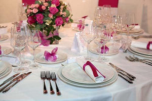 White tablecloth and napkins with flowers and gifts on the table