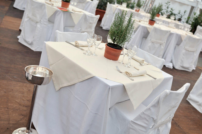 Layered white and ivory table linens in an outdoor restaurant scene