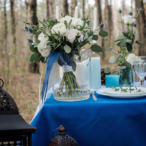 Blue wedding tablecloth set outdoors in a wooded  area 