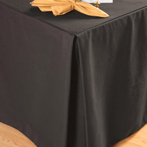 Formal black linens with a pleated corner and gold napkin and placement card