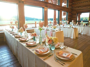 Formal Wedding linens on tables during a cabin-style reception by windows with Mountains in the back