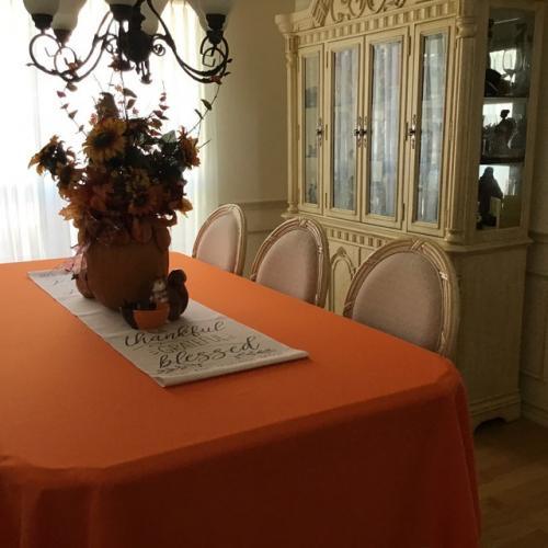 Orange table linens rectangular home table with a flower centerpiece