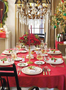 Holiday red table linens on lavishly designed holiday table, with plates and silverware