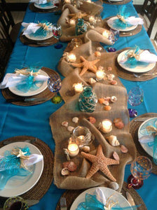 Fine linens on a Beach themed dining table with a burlap runner and beach style decorations