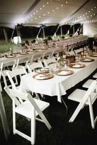 Formal table linens on a table in an Exquisite outdoor celebration under a tent