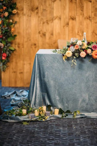 Velvet wedding linens on table with flowers and water bottle