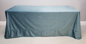 Velvet tablecloth on a rectangular table in front of a blank wall