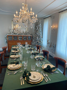 Formal table linens in an elegant winter Holiday decorated room with napkins & a Christmas tree