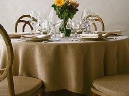 exquisite Panama dinner linens on a round table with a setting for 4 with napkins and flowers
