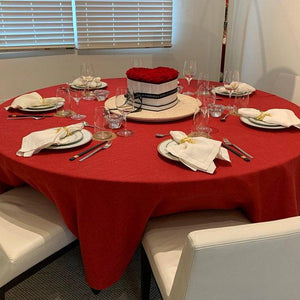 Our Panama table linen in red on a round dining table with a Valentine's Day set up and flowers