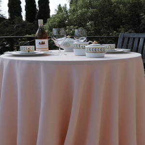 Elegant outdoor linens on a round table with glasses and tea cups 