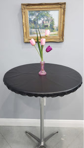 Black round fitted tablecloth with a vase of tulips on the table