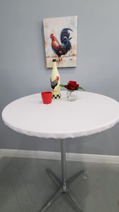 Fitted White Vinyl tablecloth on table with bottle, cup, and red rose 