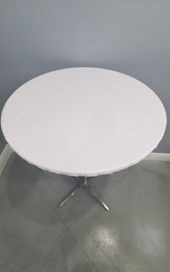 overhead view of a white round vinyl fitted tablecloth