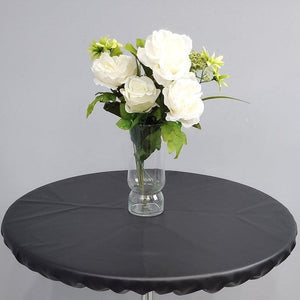 Black round vinyl fitted tablecloth with a vase of white roses