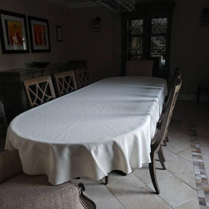 White cotton linens on an empty table in a dark dining room