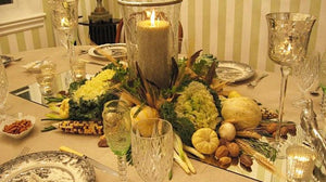 Festive Holiday table linens with harvest centerpiece and candles during a Thanksgiving celebration