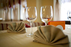 Beige Poly Cotton Twill Tablecloths and matching napkins on a restaurant table