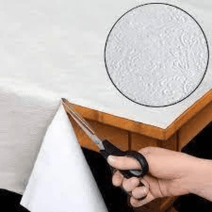 Image showing a white table pad being trimmed to size with a pair of scissors