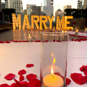 White velvet aisle runner with flowers and candles in a rooftop wedding proposal